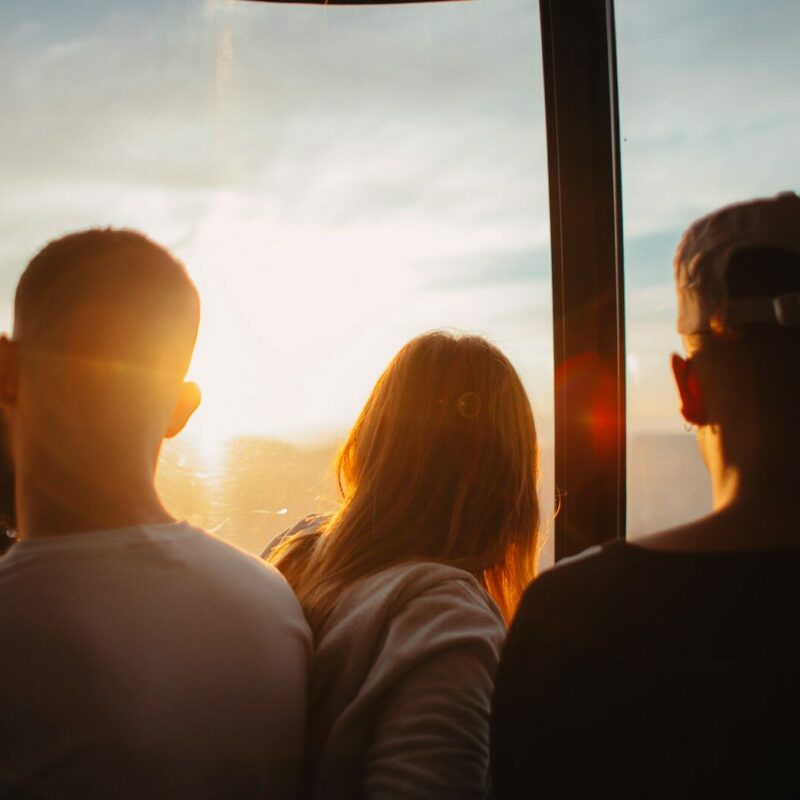 three people standing each other during golden time